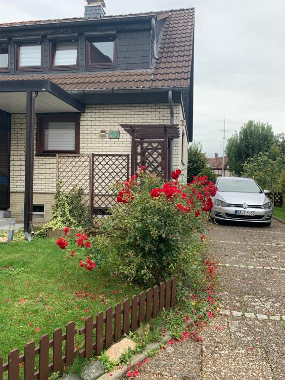 um carro estacionado em frente a uma casa com flores vermelhas em MyCha2 Ferienhaus em Goslar