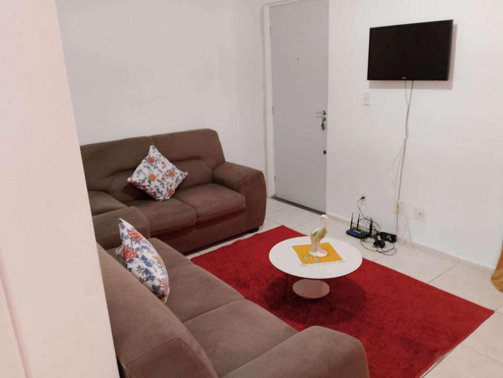 a living room with a couch and a red rug at Apartamento Padrão 1° andar in Vespasiano