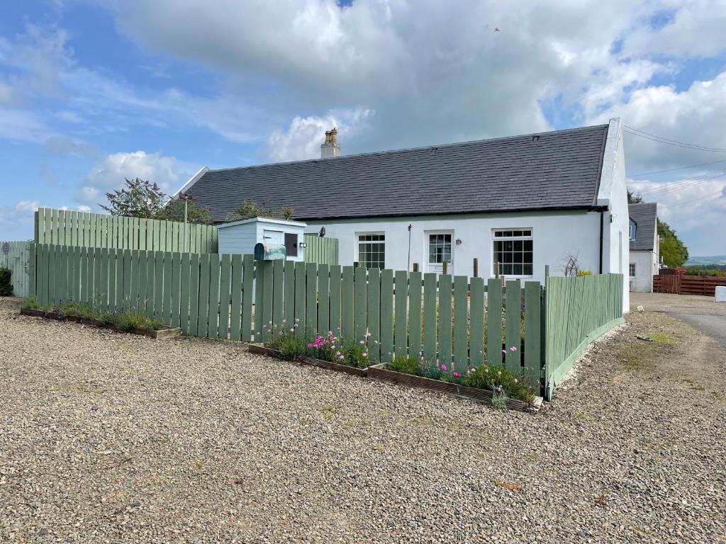 a white house with a green fence and a picket at No 2 Ramageton in Troon