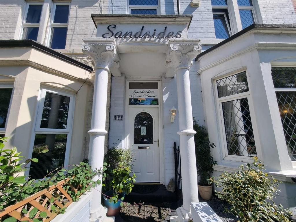 uma casa branca com um cartaz que lê sanduíches em Sandsides Guest House em Whitley Bay