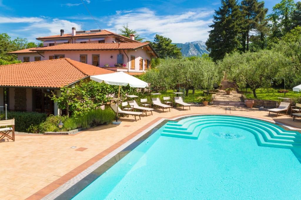 a swimming pool in front of a house at Hotel Il Buongustaio in Massa