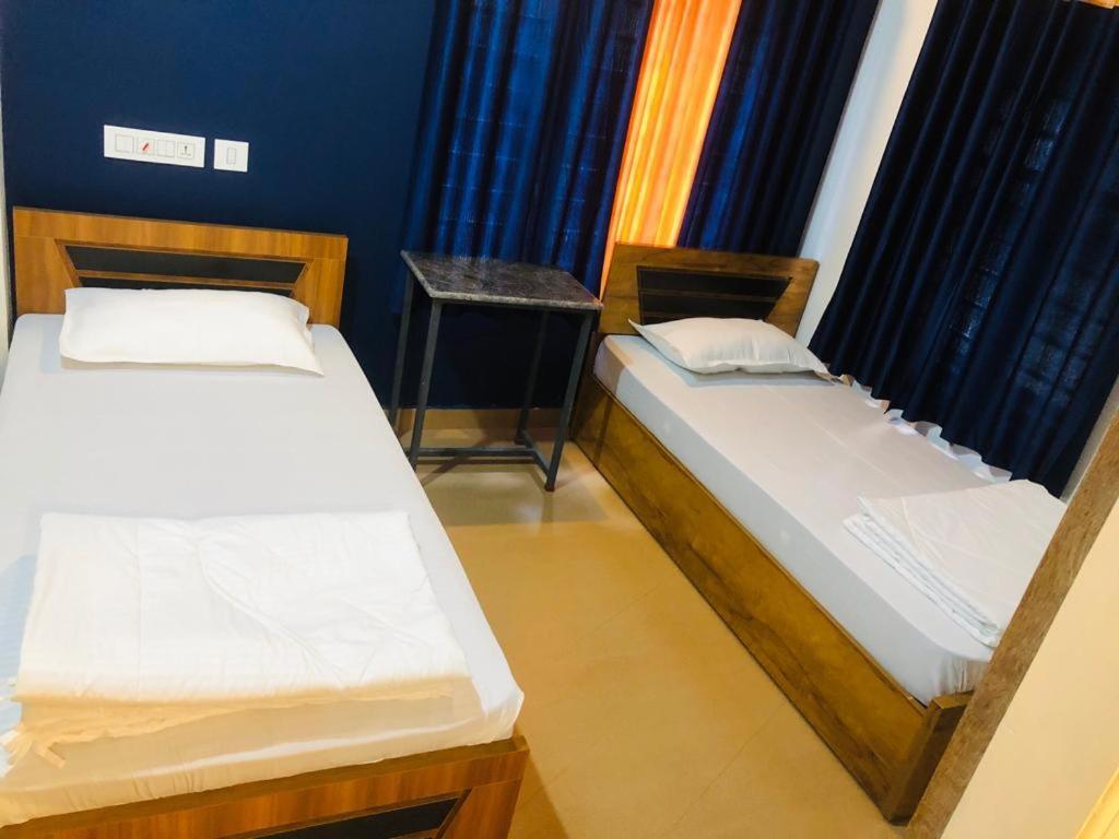 a room with two beds and a table in it at Royal residency in Tindummal