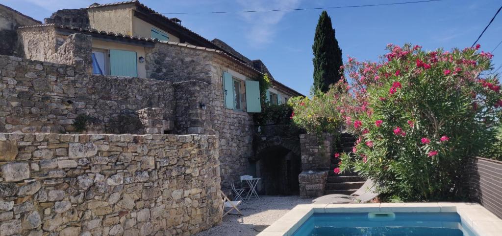 une maison avec un mur en pierre et une piscine dans l'établissement La Closerie de la Cèze, à Cornillon