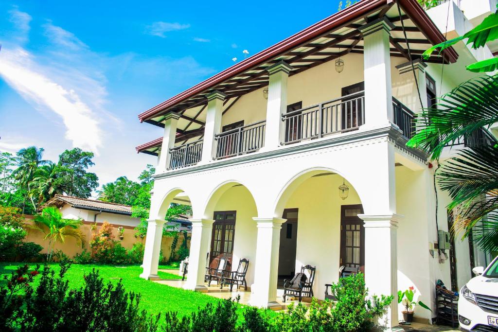 a large white house with a green yard at Villa71 in Galle