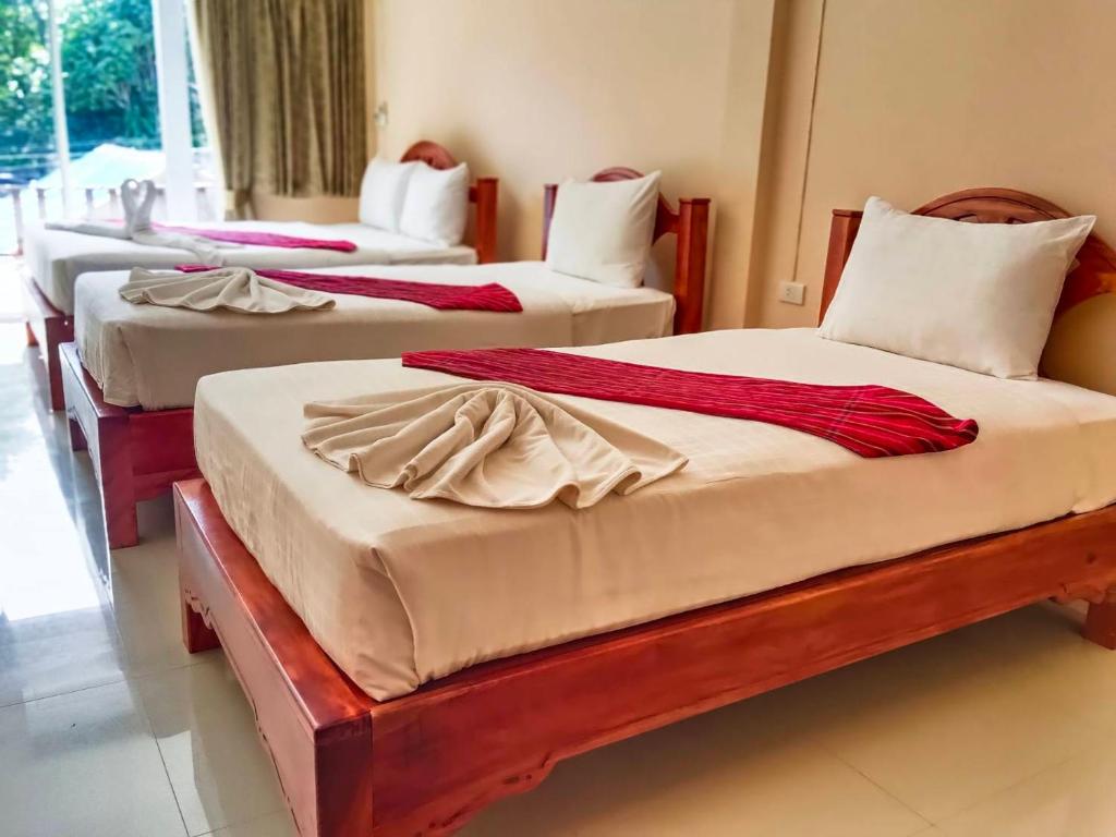 a group of four beds in a room at Khao-Sok Bed and Breakfast in Khao Sok National Park