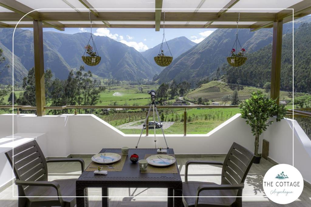 a dining room with a view of the mountains at The Cottage Angochagua in Ibarra