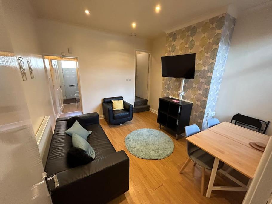 uma sala de estar com um sofá e uma mesa em Practical and Spacious Property em Stoke-on-Trent