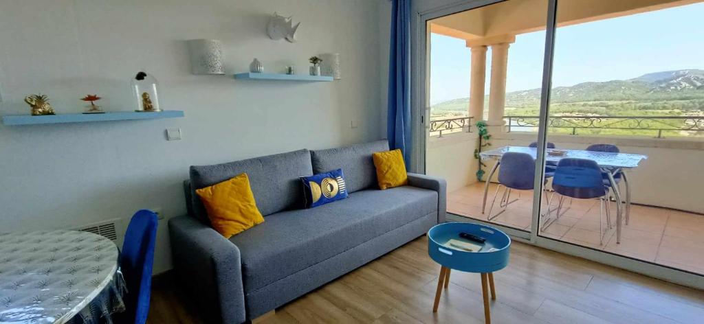 - un salon avec un canapé et une table dans l'établissement Appartement vue panoramique au domaine et golf de pont royal, à Mallemort