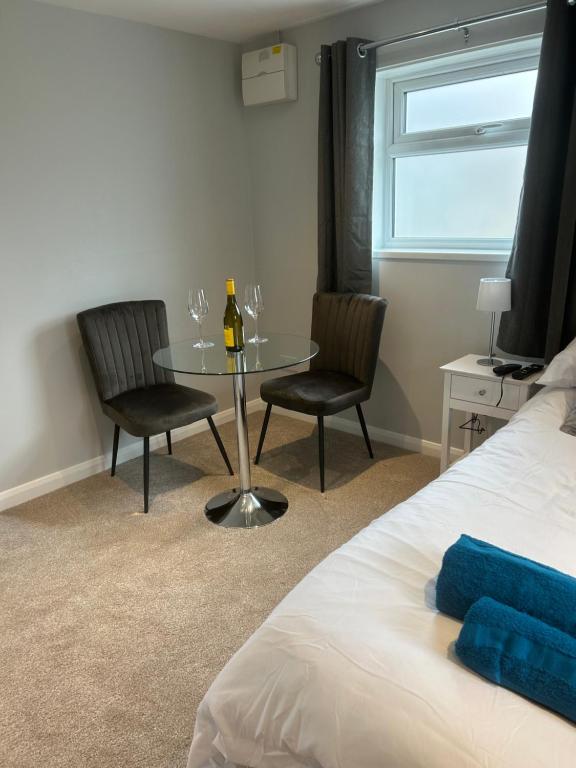 1 dormitorio con mesa, 2 sillas y 1 cama en 29a, en Downham Market