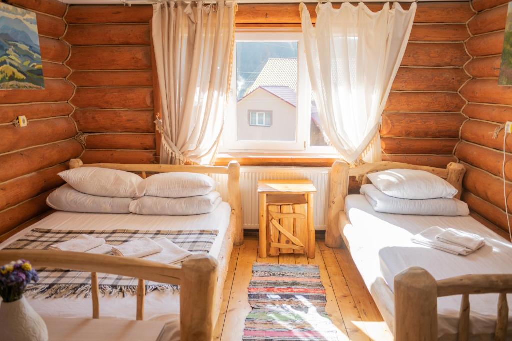 two beds in a room with a window at Будинок Художника in Synevyrsʼka Polyana