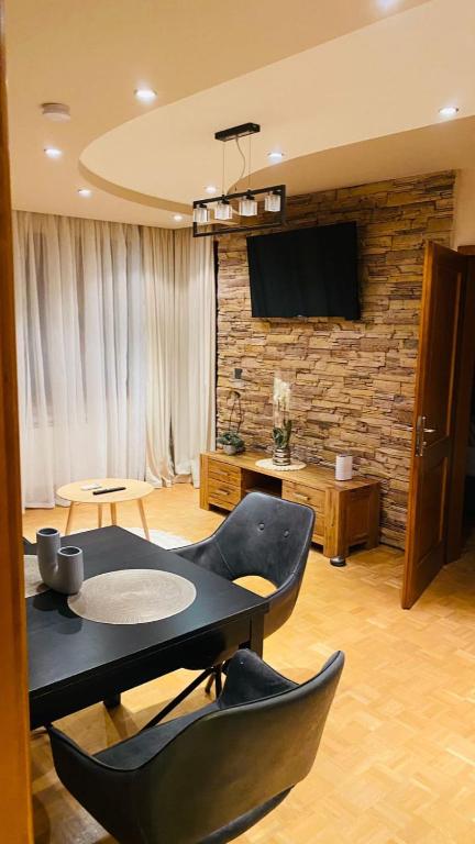 a living room with a table and chairs and a tv at Eda Aparts in Devin