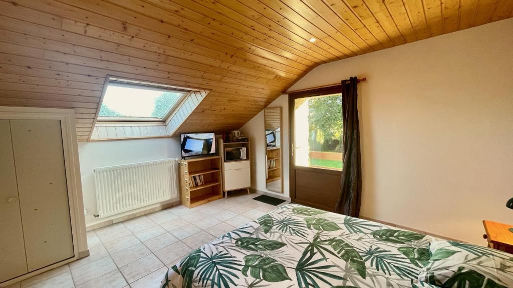 1 dormitorio con 1 cama en una habitación con ventana en Chambres Les Tilleuls, en Poullaouen