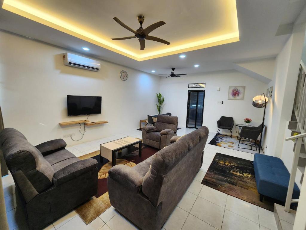 a living room with couches and a flat screen tv at Pangeran Homestay Pokok Sena in Kampong Joo