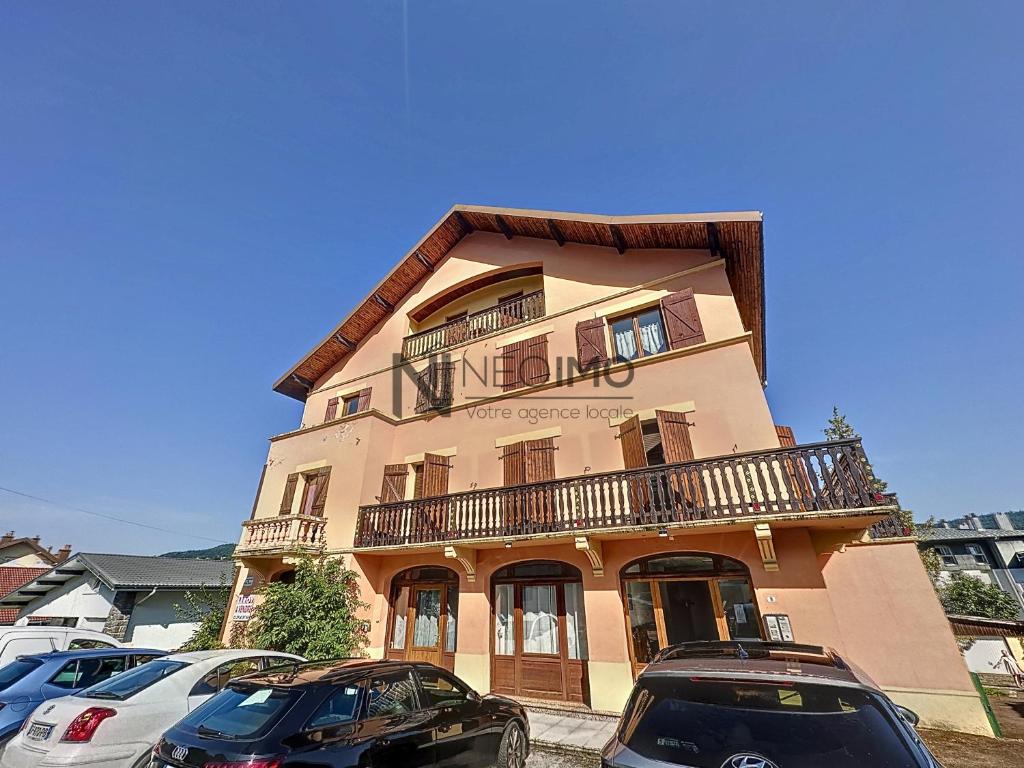 un bâtiment avec des voitures garées devant lui dans l'établissement lac et montagne Gerardmer, à Gérardmer