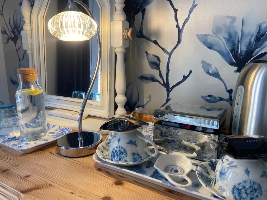 una mesa con jarrones azules y blancos y un espejo en Abbey Green Farm en Wem