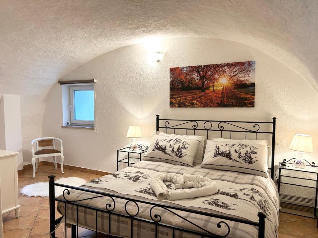 1 dormitorio con 1 cama con una pintura en la pared en Appartamento Nel Verde, en Bracca