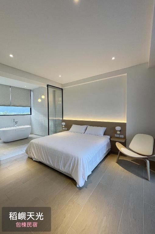 una camera con letto, sedia e vasca di 稻嶼天光包棟民宿 a Città di Yilan