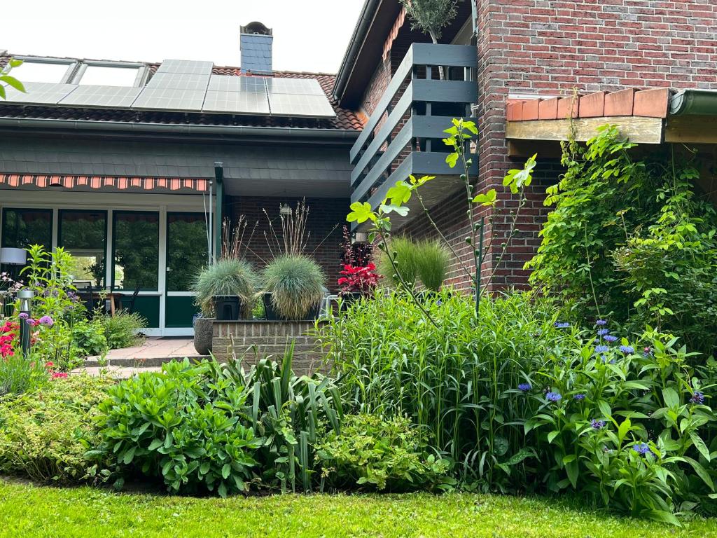 einen Garten vor einem Haus mit Pflanzen in der Unterkunft Aussergewöhnliches Haus mit Sauna, Kamin und Garten in Wilhelmshaven