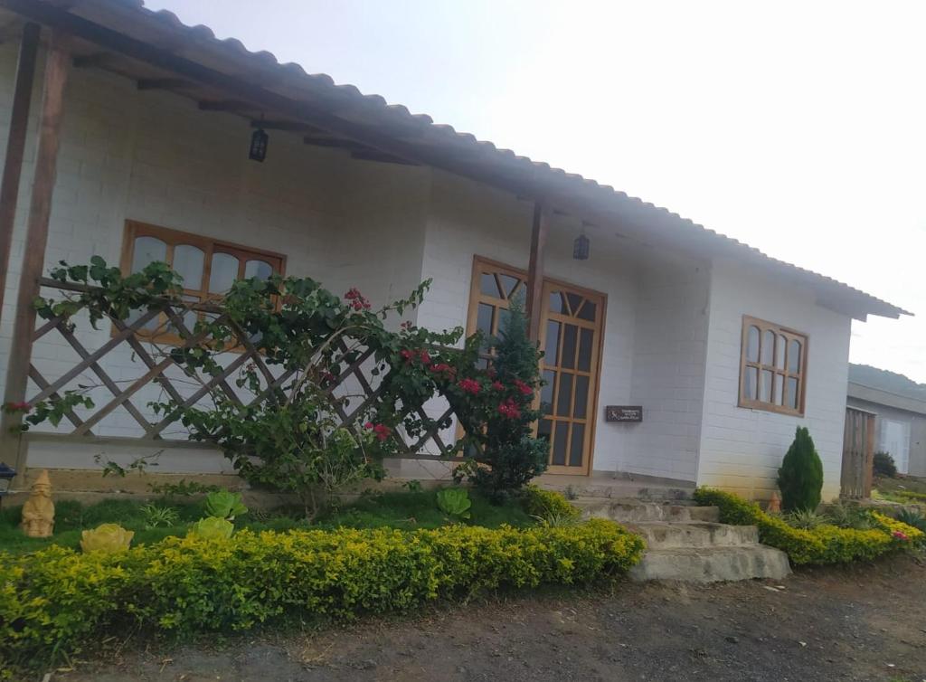 uma casa com flores em frente em Cabaña Milan em San Gil