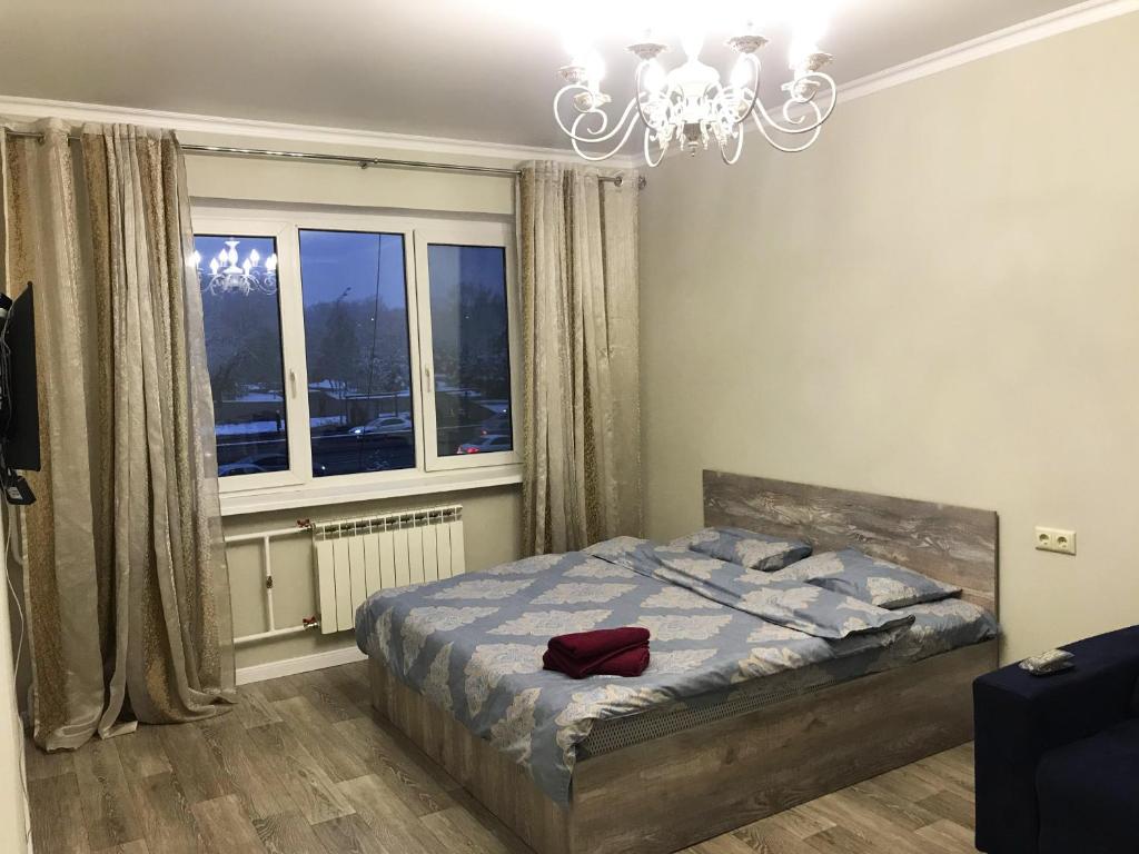 a bedroom with a bed and a chandelier at Asaapart Al-Farabi 131/8 in Almaty