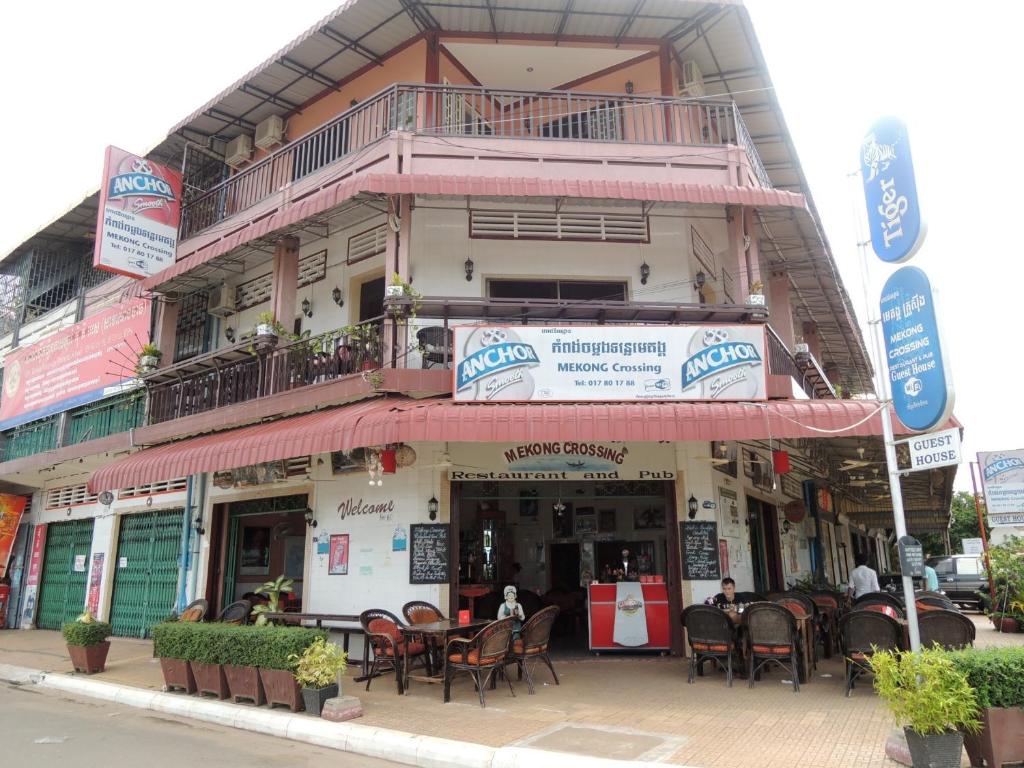a restaurant with tables and chairs in front of a building at Mekong Crossing Guesthouse - Restaurant & Pub in Kampong Cham