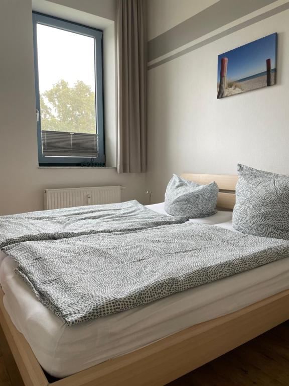 um quarto com uma cama grande e uma janela em Ferienwohnung Fehmarn am Südstrand em Fehmarn