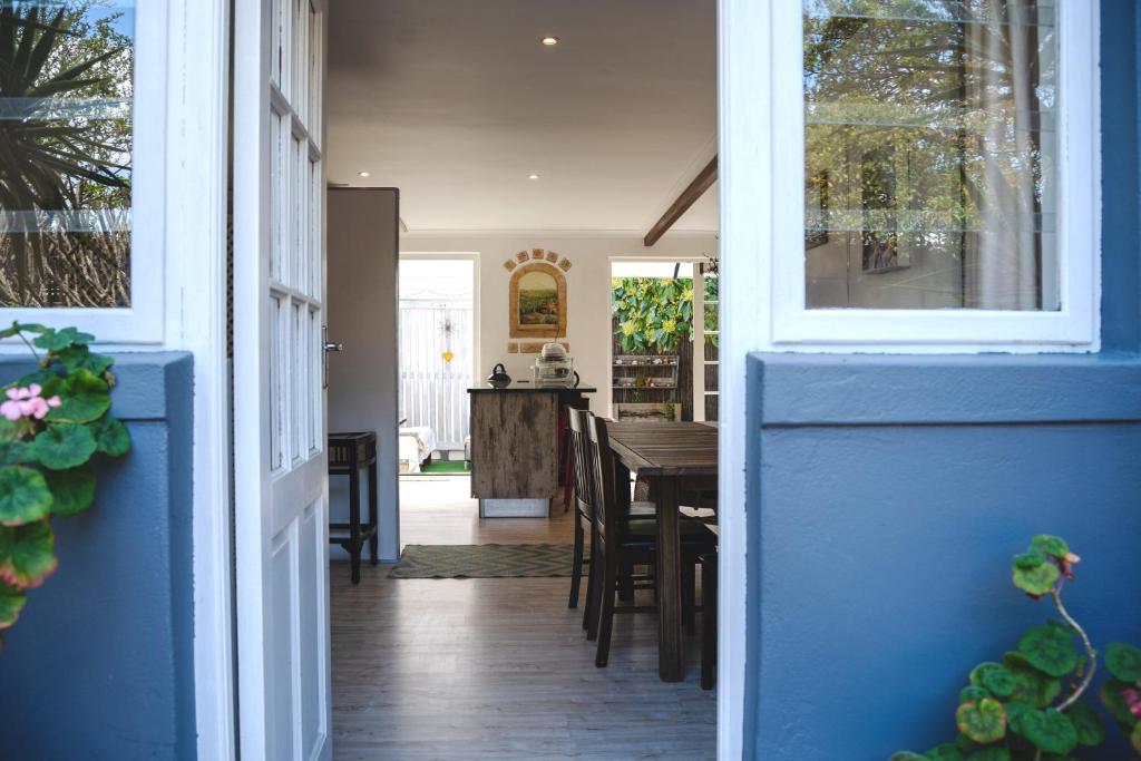 a room with a blue door and a dining room at Nirvana Cottage in Cape Town