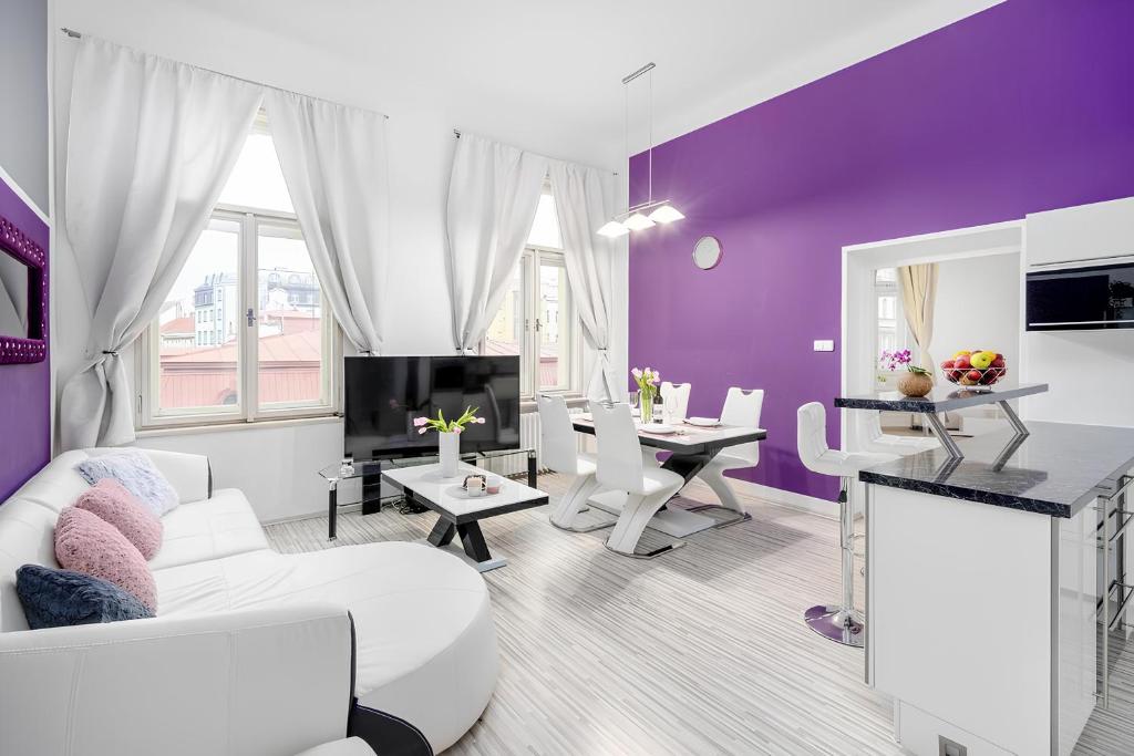 プラハにあるLuxury 3KK Apt w/2KINGBeds 65”TV,Next Wenceslas Sqの紫の壁と白い家具が備わるリビングルーム