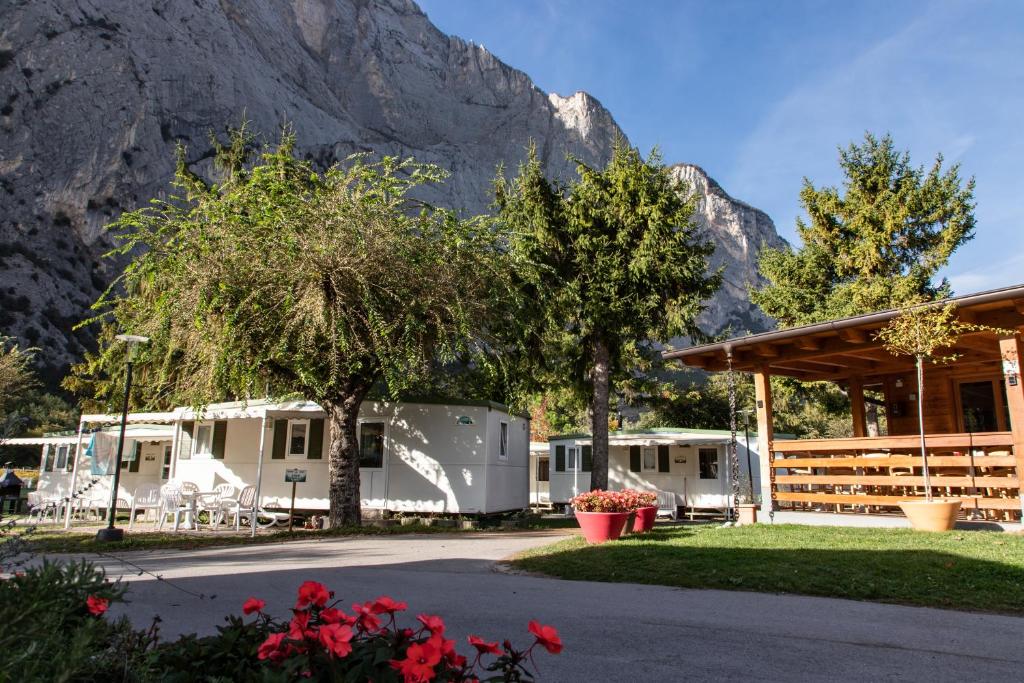 a group of rvs parked in front of a mountain at Camping Daino in Pietramurata