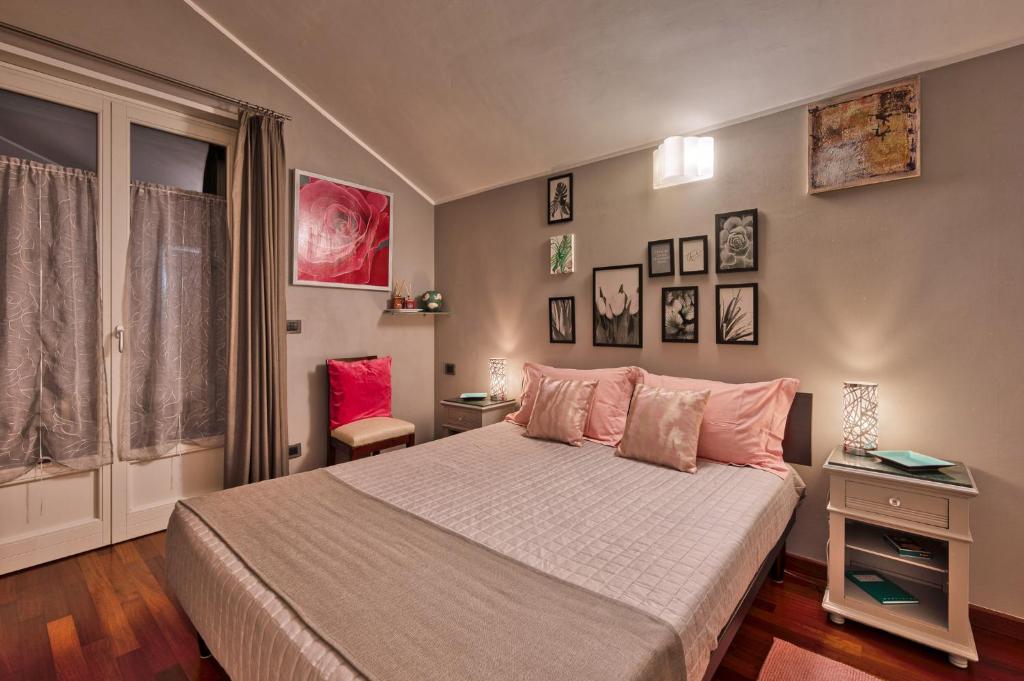 um quarto com uma cama grande e almofadas cor-de-rosa em La Stanza dei Sogni em Saluzzo