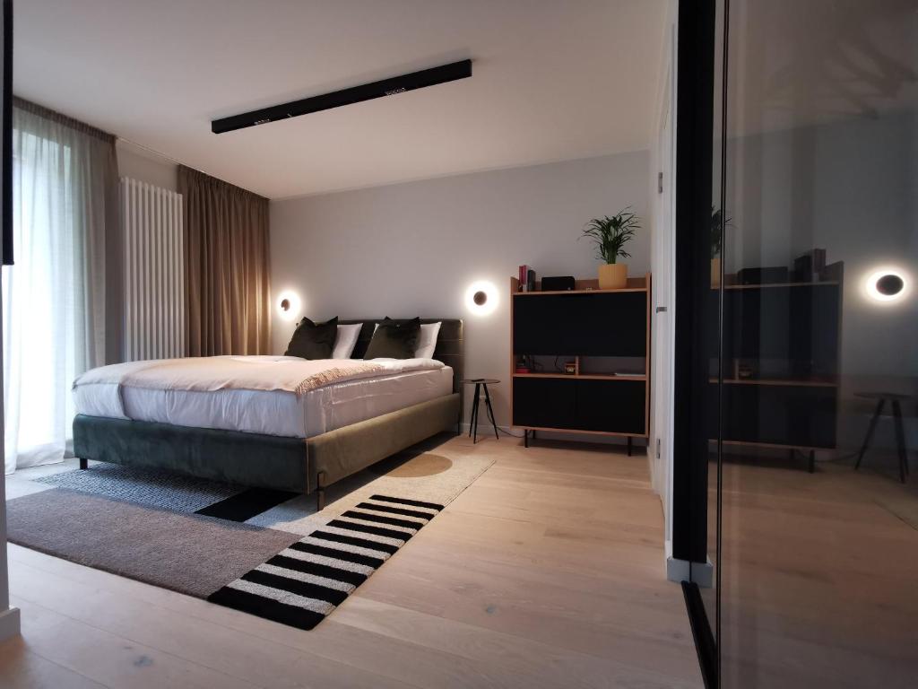 a bedroom with a bed and a large window at Albatross RELAX seaside design apartment with terrace in Ķesterciems