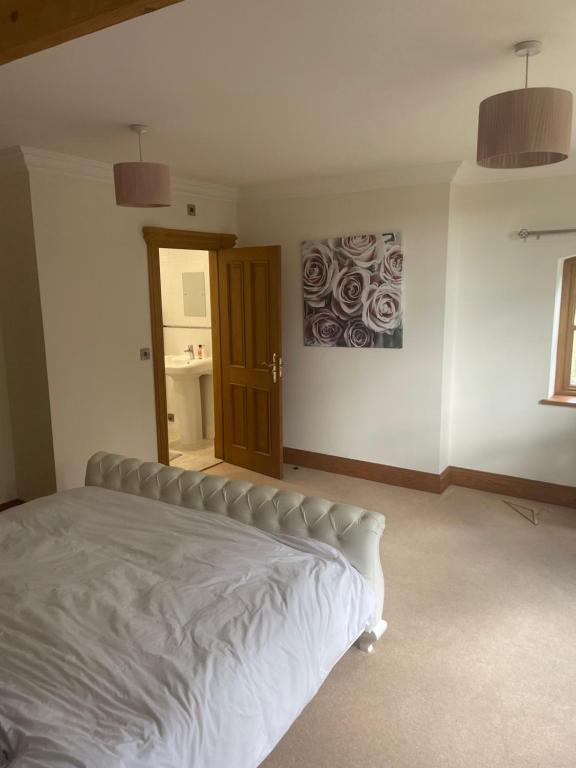 a bedroom with a white bed and a window at Dairy farm in Crewe