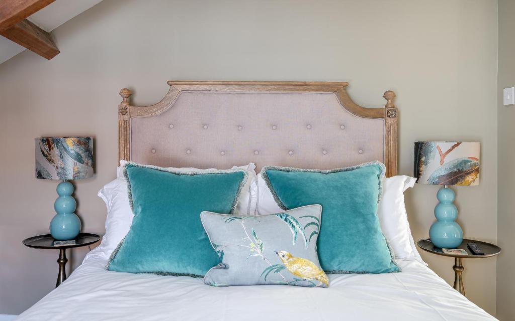 a bed with blue pillows and a headboard at No93 Boutique Guest House in Easingwold