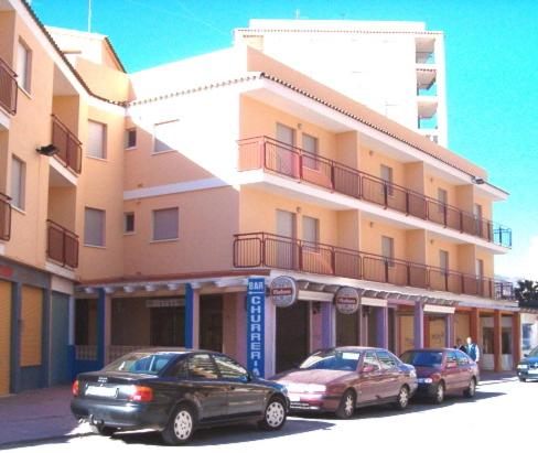 two cars parked in front of a building at Apartamentos Parada in Oropesa del Mar