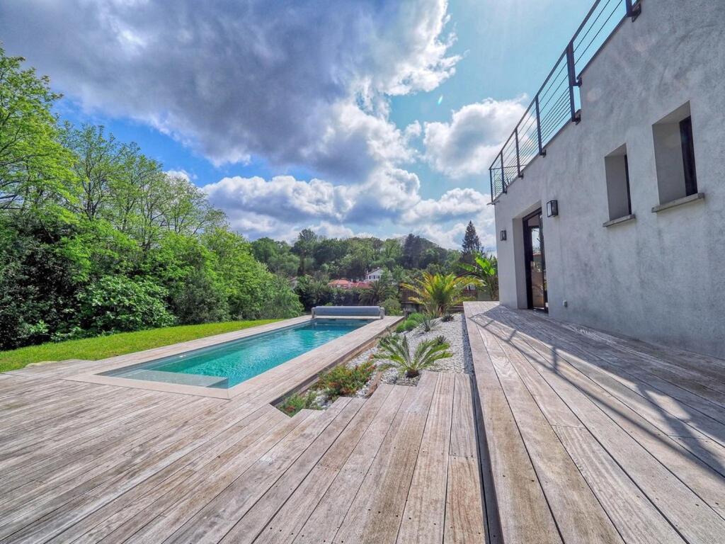 a backyard with a swimming pool and a wooden deck at VILLA MADHUKA - Chambres d'hôtes in Hendaye