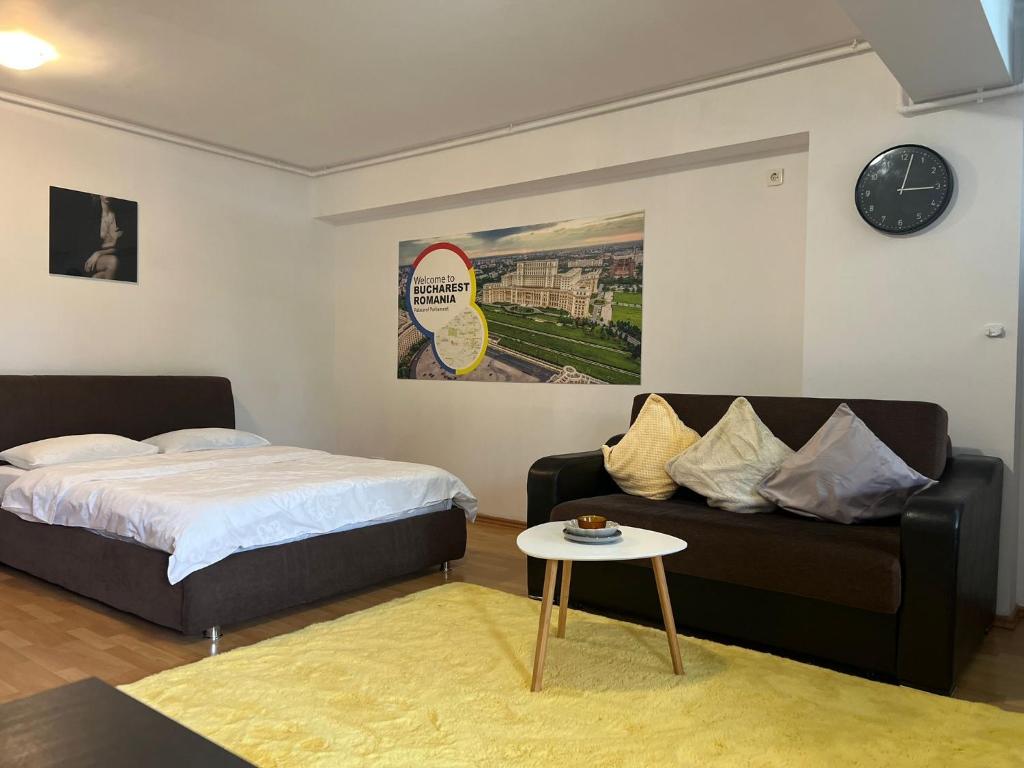 Un dormitorio con una cama, un sofá y una mesa. en Tranzzit Airport Apartament, en Otopeni
