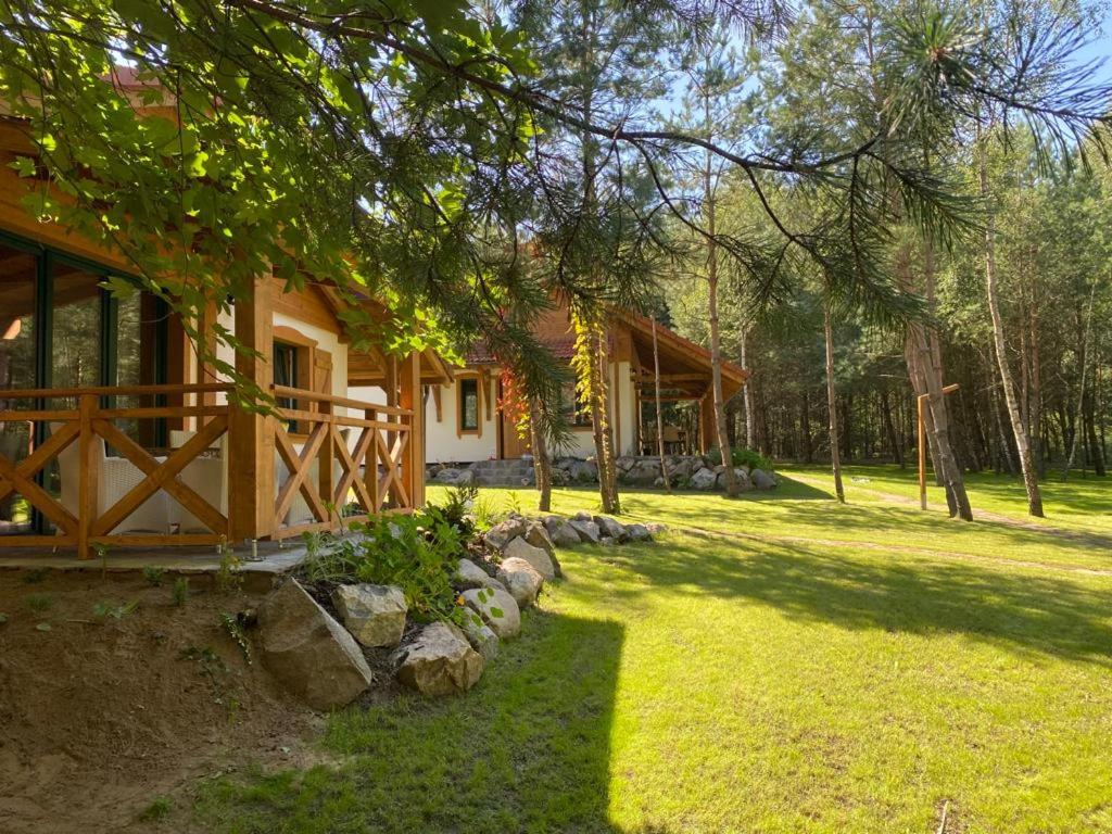 una casa con un cortile accanto a un edificio di Leśna Kryjówka domki w lesie a Wersk