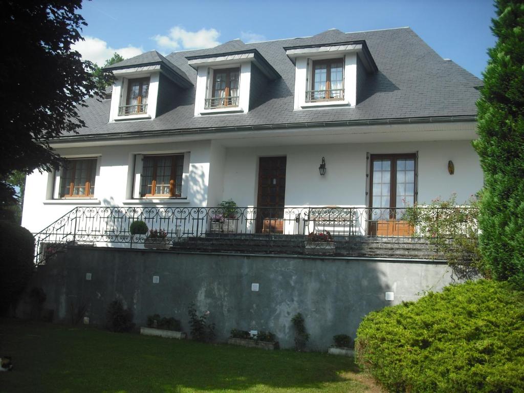 een wit huis met een grijs dak bij Chambres d'Hôtes La Plantade in La Barthe-de-Neste