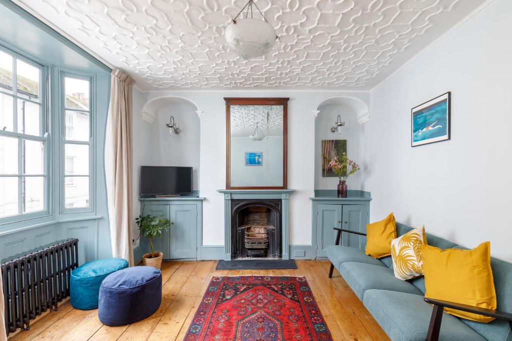 a living room with a blue couch and a fireplace at Artists' Home - North Laine in Brighton & Hove