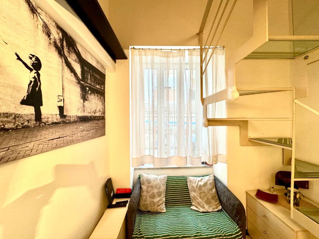 Kleines Zimmer mit einem Fenster und einem grünen Bett in der Unterkunft Casetta San Martino in Neapel