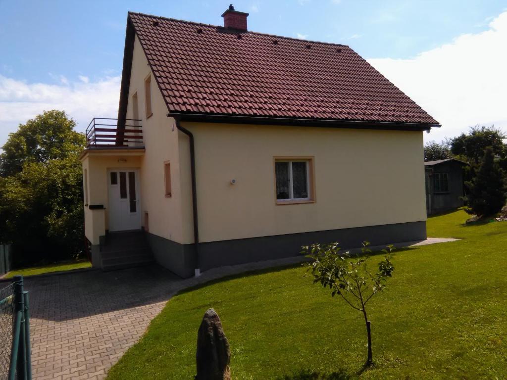 uma pequena casa branca com um telhado vermelho em Rodinný dům Na Smetance em Vrchlabí