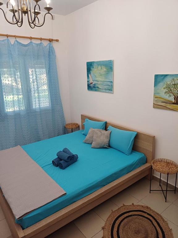 sypialnia z dużym łóżkiem z niebieską pościelą w obiekcie APARTMENTS ON THE BEACH w mieście Velika
