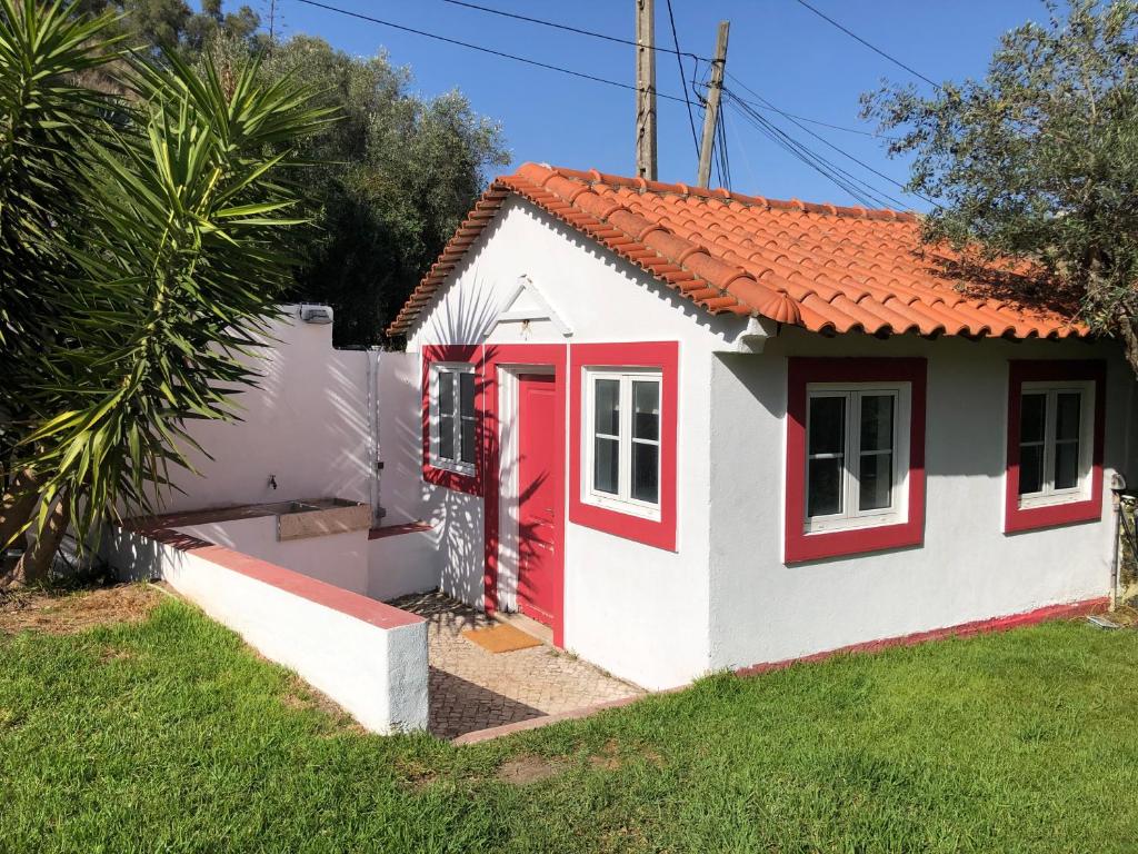 una pequeña casa con una puerta roja en Lisbon Cozy House w/Garden and Pool, en Valejas