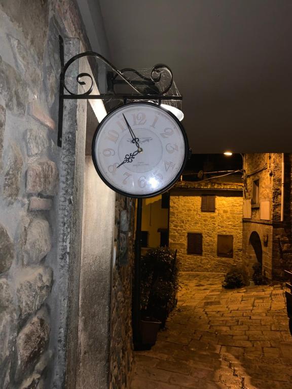 une horloge suspendue sur le côté d'un mur dans l'établissement La Rocca Sovrana - Casa Vacanze, à Aramo