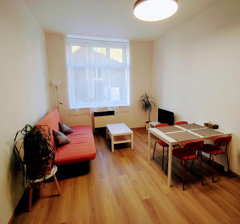 a living room with a red couch and a table at Apartman Coral in Prague
