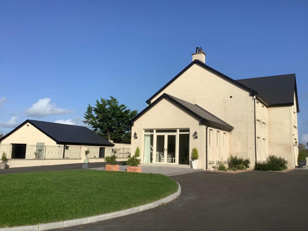 a large white house with a driveway at Radharc Na Cuilcagh in Enniskillen