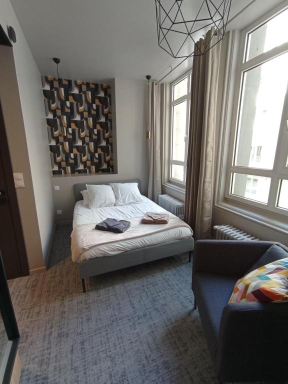 - une chambre avec un lit, un canapé et des fenêtres dans l'établissement Le 12 studio neuf wifi app 11, à Saint-Étienne