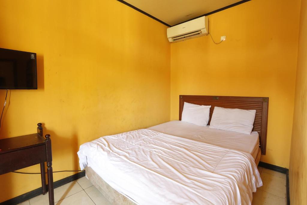 เตียงในห้องที่ OYO 93127 Penginapan Budhe Sri