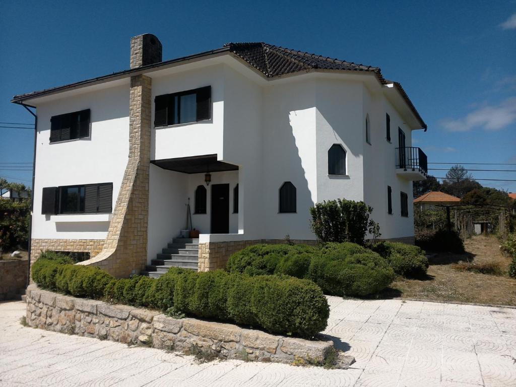une grande maison blanche avec un toit dans l'établissement Albergue Constantino AL, à Paredes de Coura