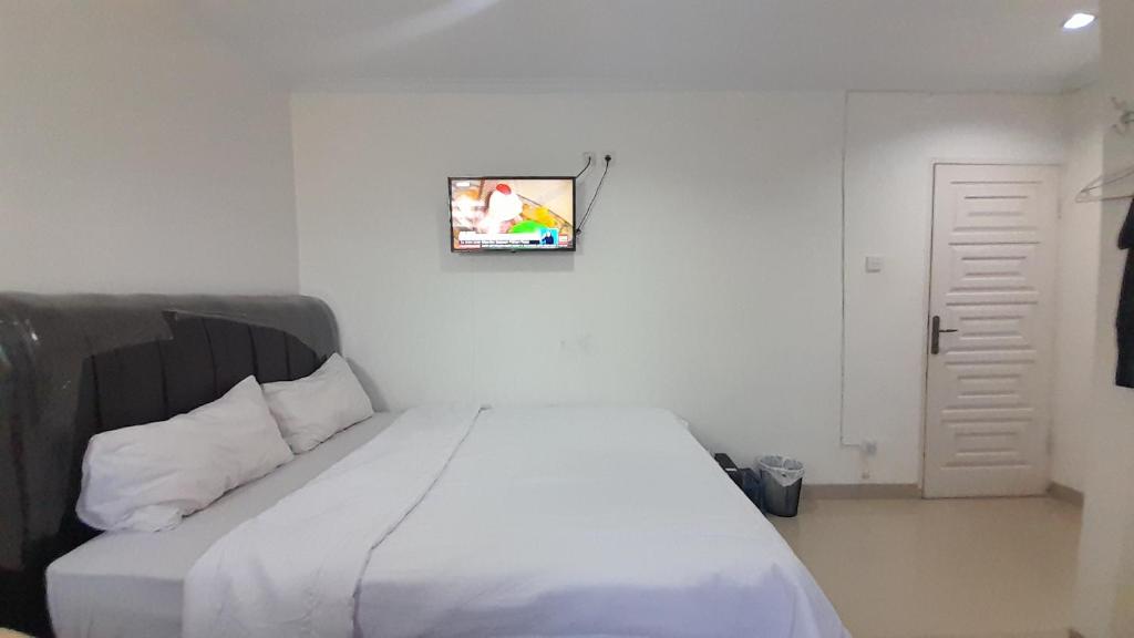 a bedroom with a white bed with a picture on the wall at OYO 931O12 Tamara Homestay Syariah in Medan